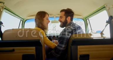 幸福的年轻夫妇在面包车里相互交流